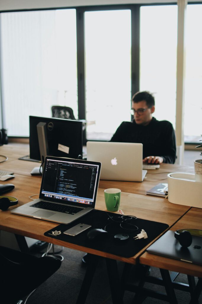 pexels-photo-2102416-2102416 A web developer working on code in a modern office setting with multiple devices.